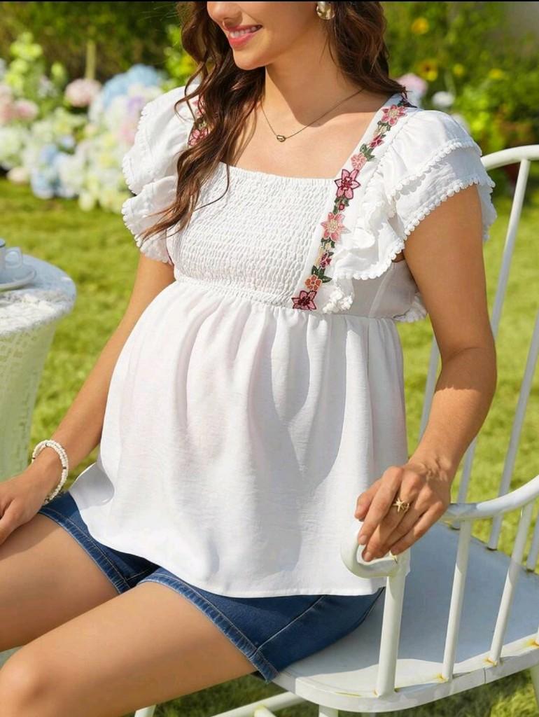 Blusa blanca de embarazada con ribete y bordado de flores